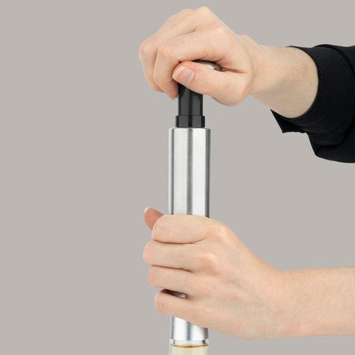 Manuelle Vakuumpumpe für Wein WOM440 im Gebrauch – Nahaufnahme der Hand, die die Vakuumpumpe auf eine Weinflasche ansetzt.