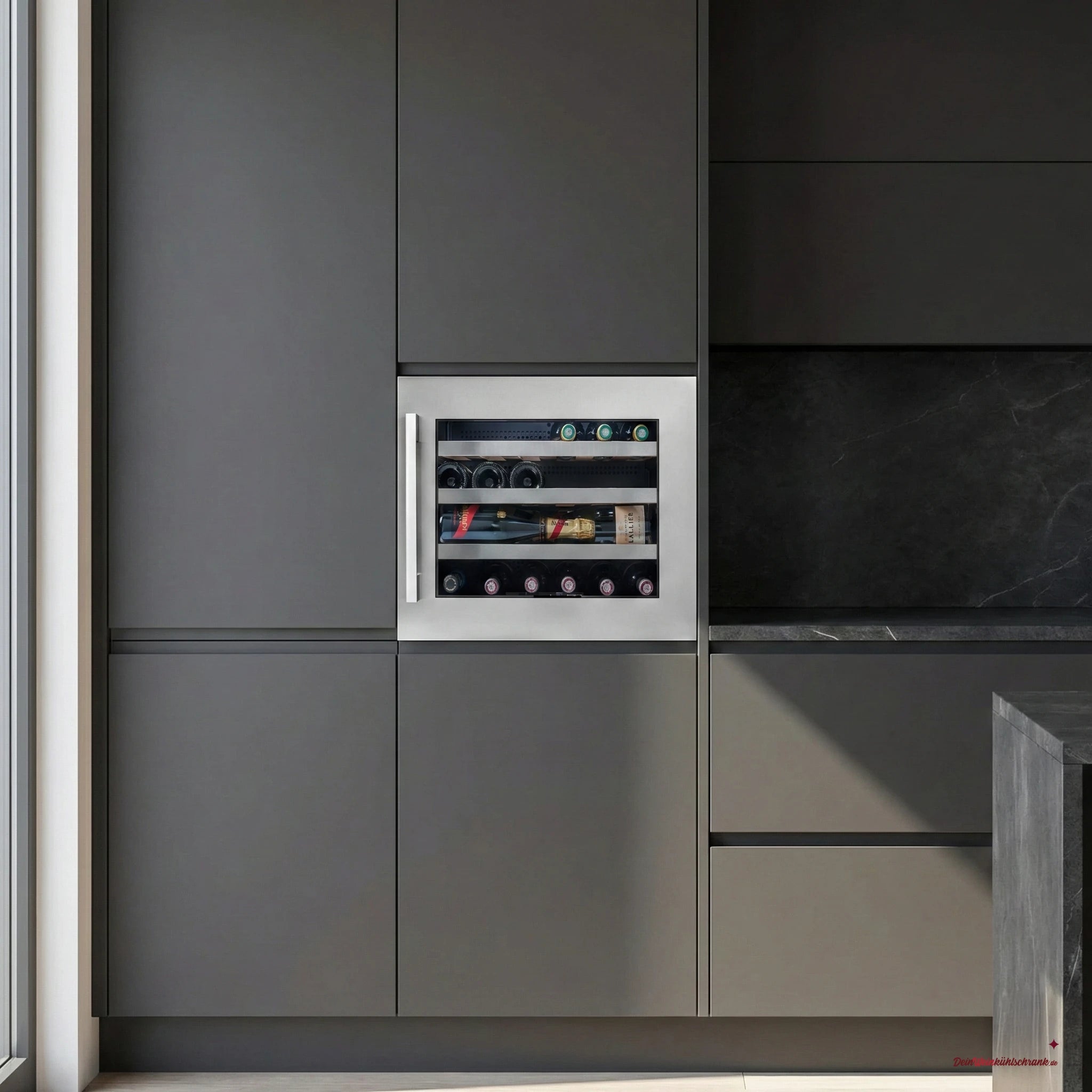 Einbau-Weinkühlschrank Avintage AVI24S2X für 24 Flaschen, integriert in eine moderne, grifflose Küchenzeile mit dunklen Fronten; hinter der Glastür mit Edelstahlrahmen sind mehrere Wein- und Champagnerflaschen horizontal auf Holzregalen gelagert.
