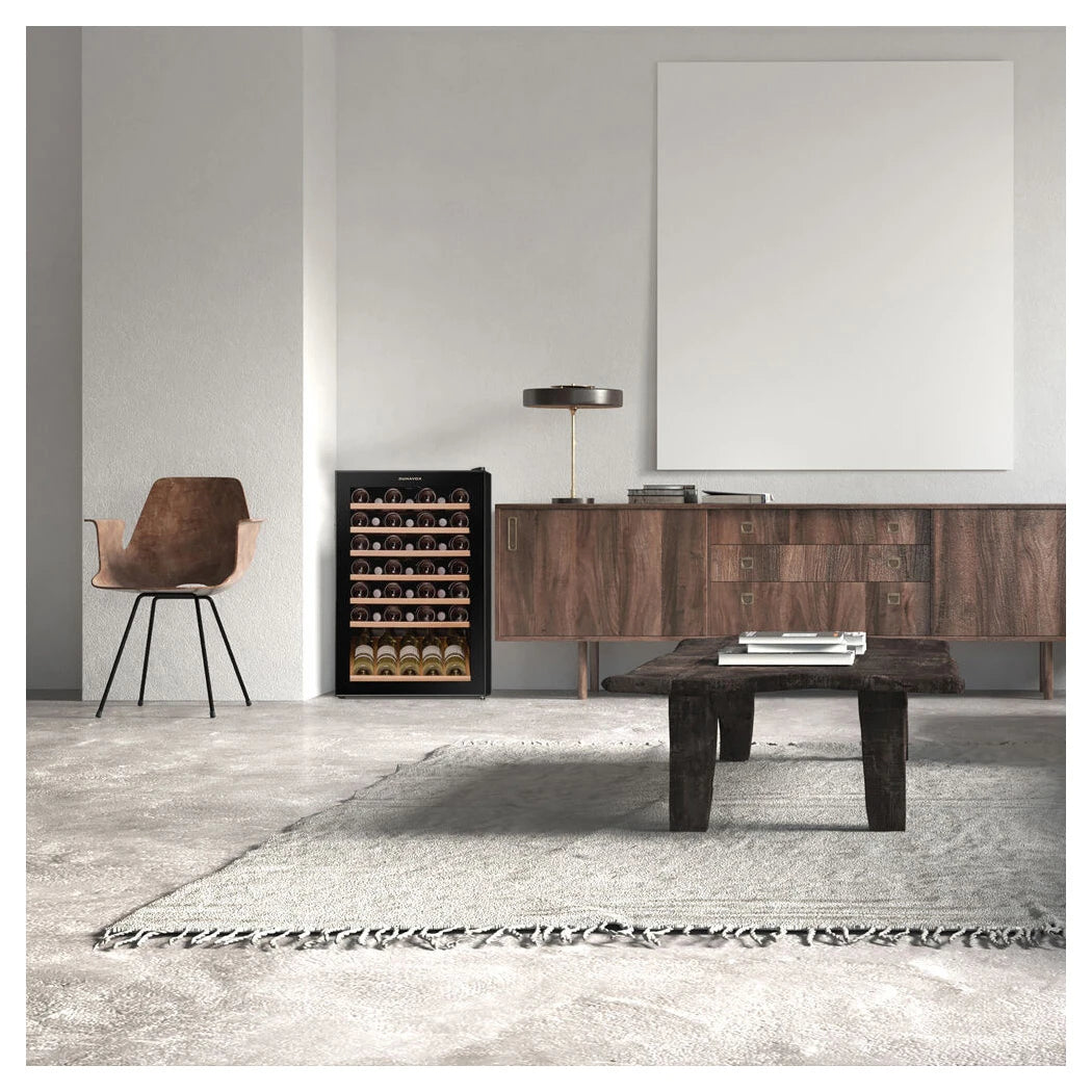 Dunavox Home-48 freistehender Weinkühlschrank in minimalistischem Wohnzimmer neben Holzsideboard und Designersessel