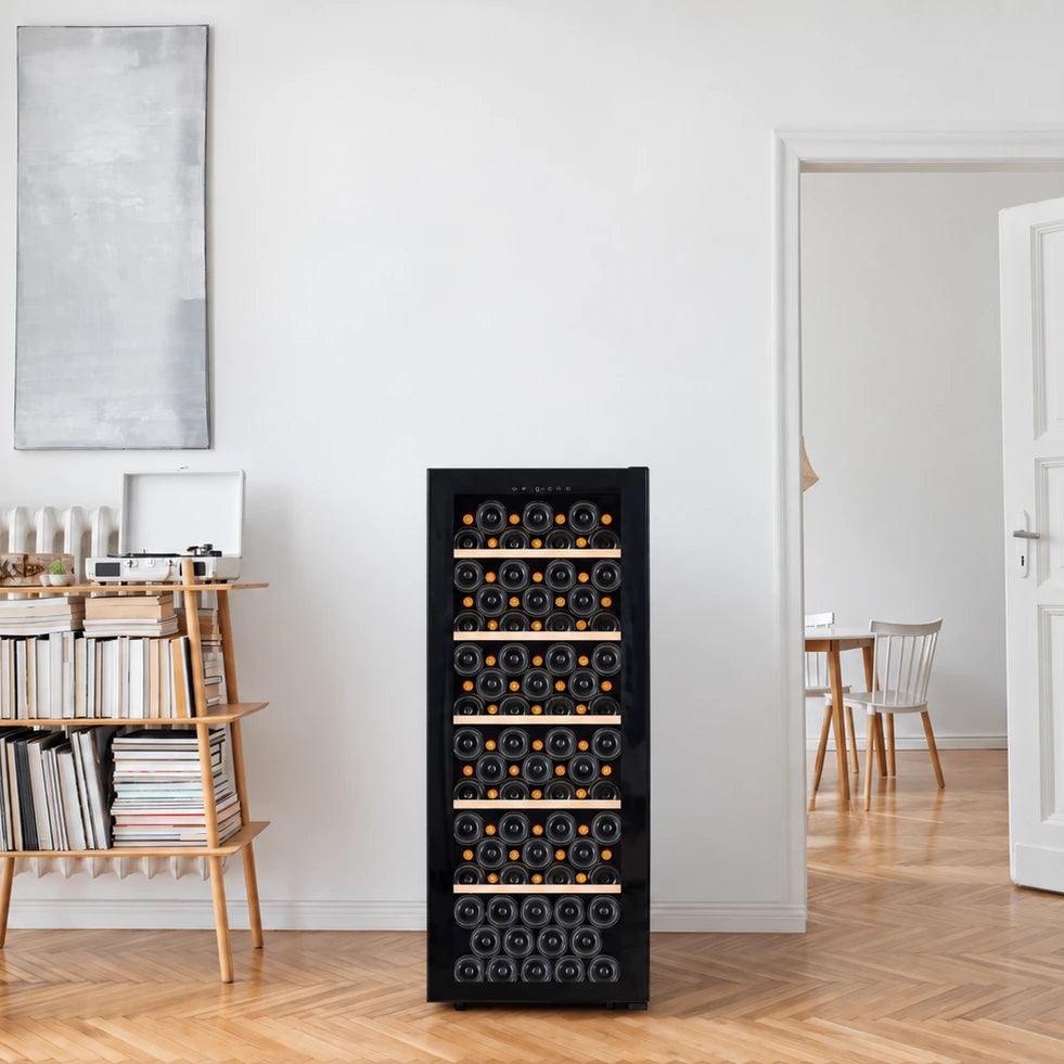 Freistehender Weinkühlschrank La Sommelière SMART112 mit Flaschen gefüllt im hellen Wohnzimmer neben einem Bücherregal