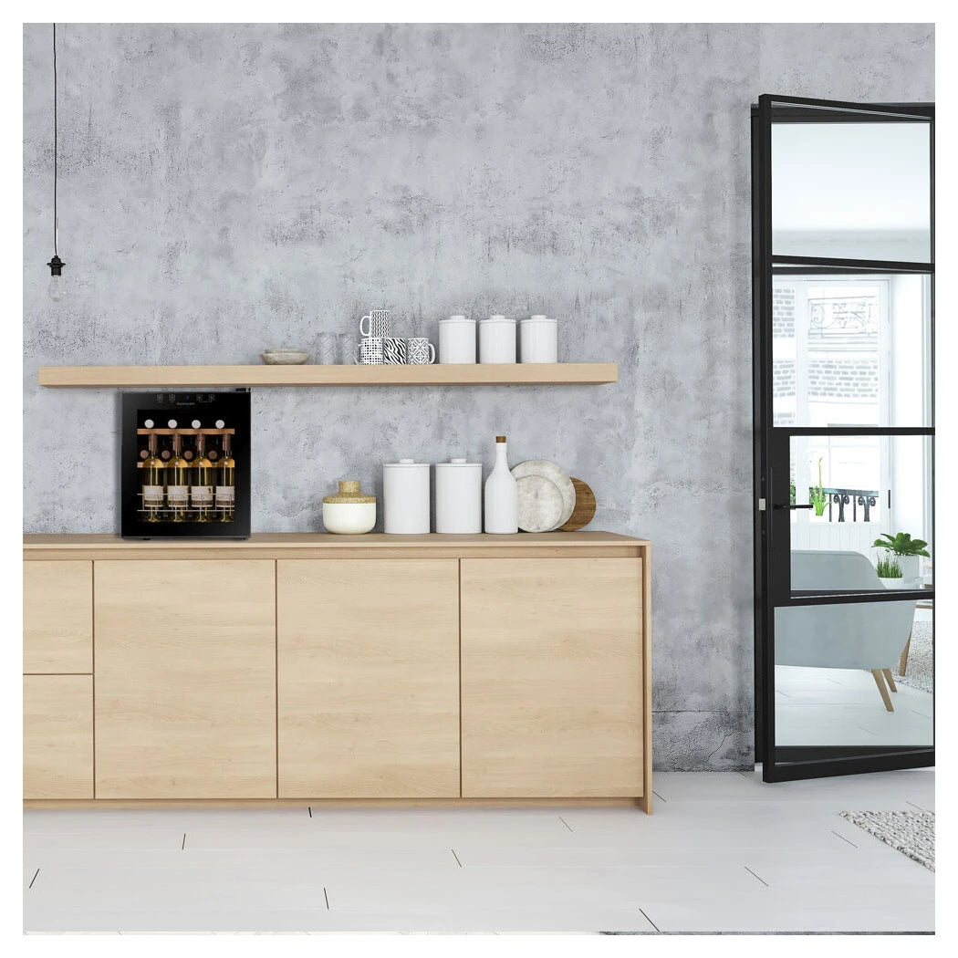 Dunavox Home-16 Weinkühlschrank in Holzsideboard, moderner Raum mit Betonwand und Spiegel, Weinflaschen sichtbar