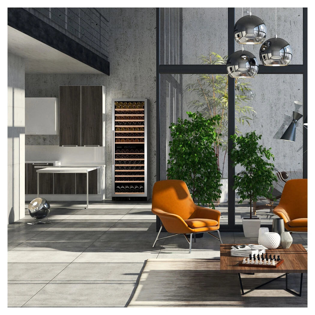 Dunavox Grande-166 Weinkühlschrank in modernem Wohnzimmer mit Betonwänden, orangefarbenen Sesseln und Hängeleuchten