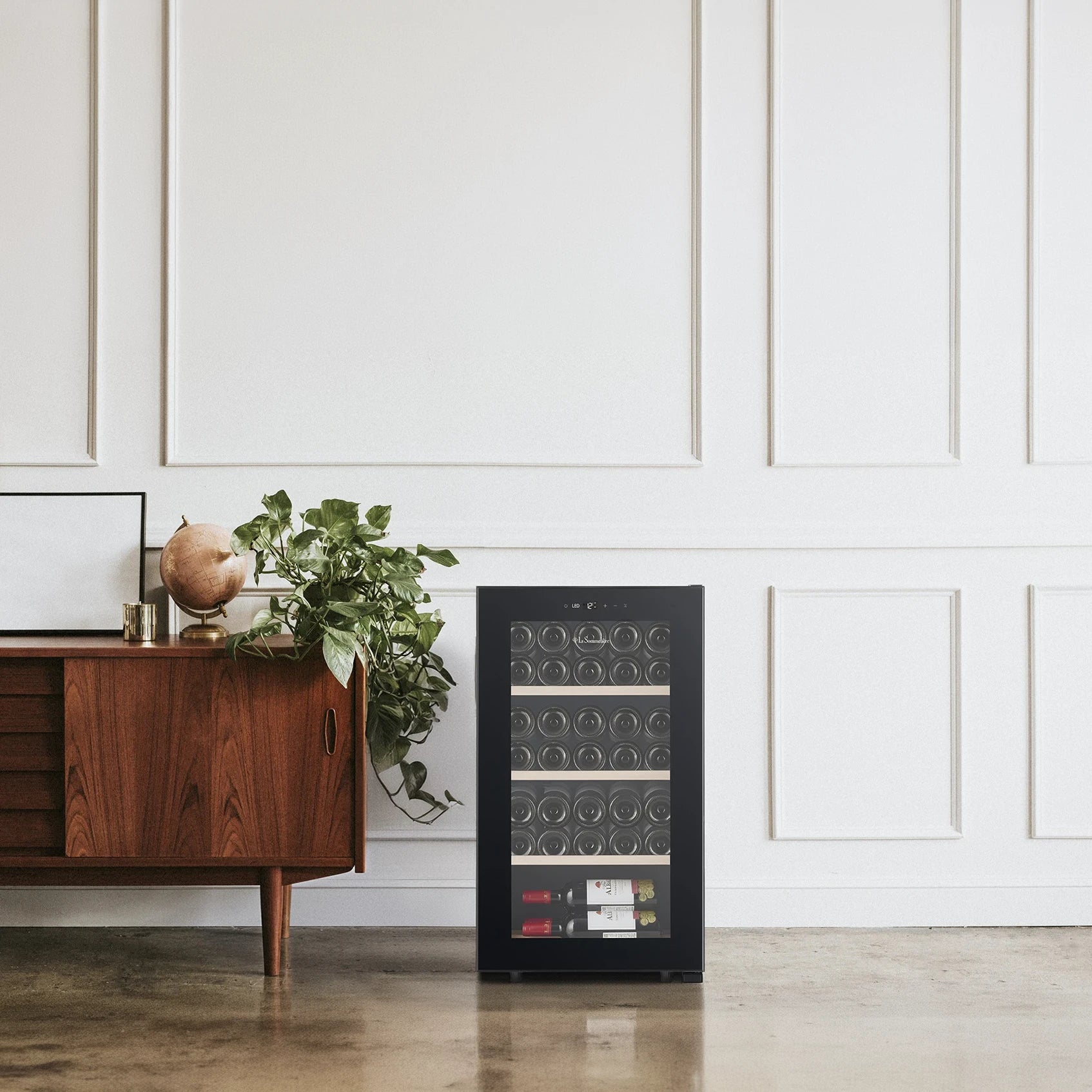 Freistehender Weinkühlschrank La Sommelière SMART36 im Wohnraum neben einem Sideboard aus Holz