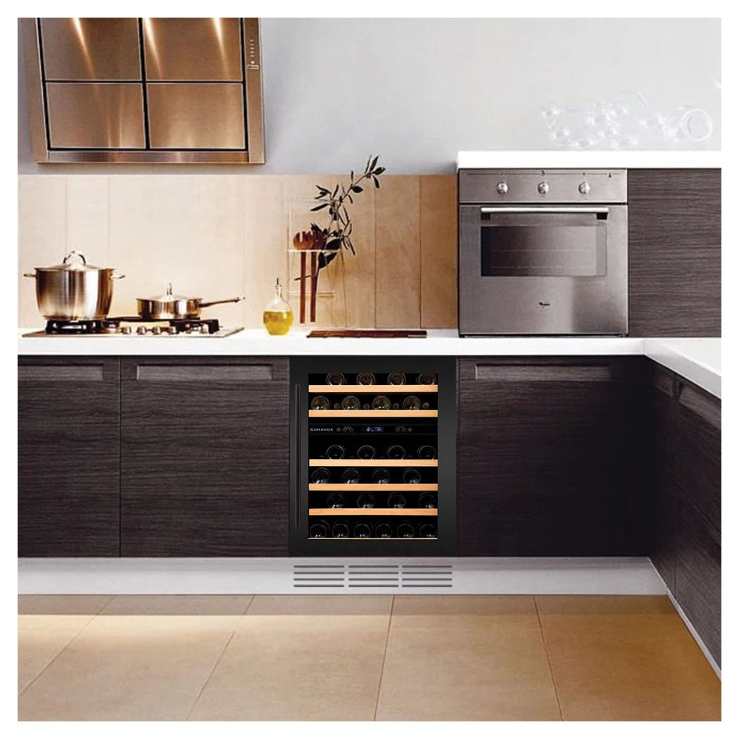 Dunavox Flow-46D Black Weinkühlschrank als Unterbau in dunkler Holzküche mit Gasherd und integriertem Backofen