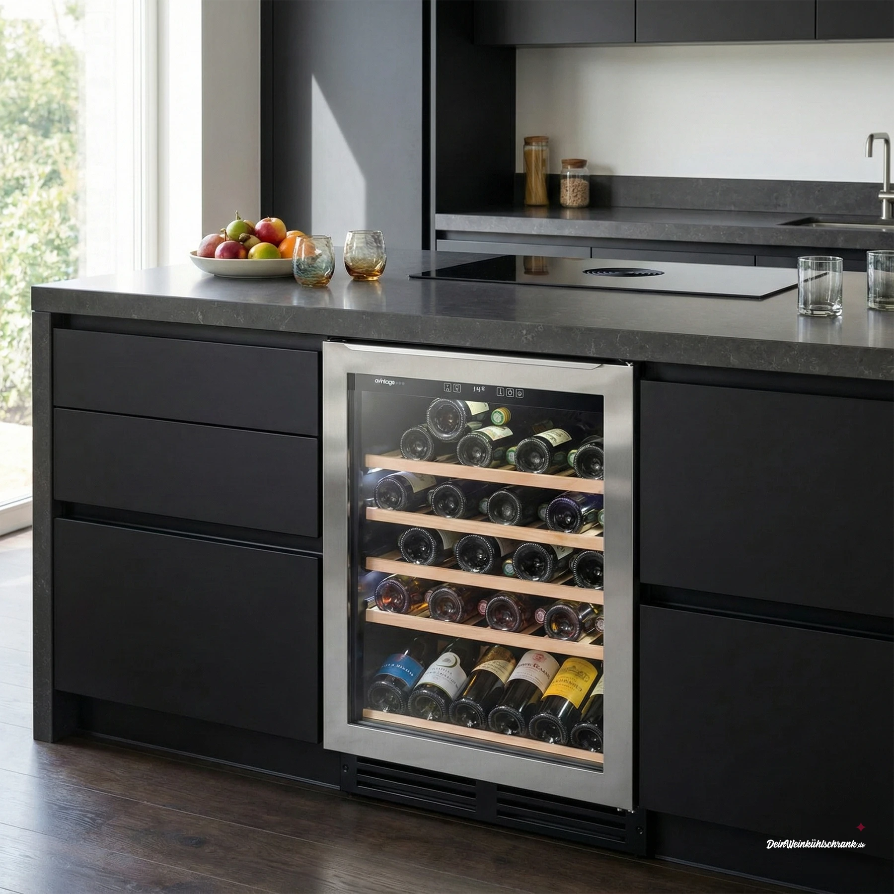 Einbau-Weinkühlschrank Avintage AVU52TX1 für bis zu 53 Flaschen, mit Edelstahlrahmen und Glastür, integriert in eine moderne Kücheninsel mit dunklen Fronten und Arbeitsplatte in Steinoptik.